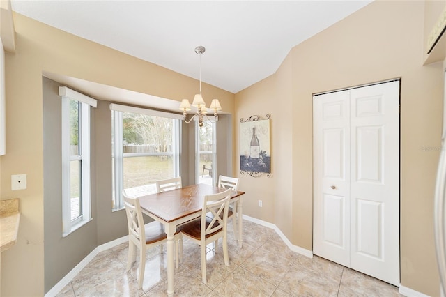 dining space with vaulted ceiling, plenty of natural light, and a notable chandelier