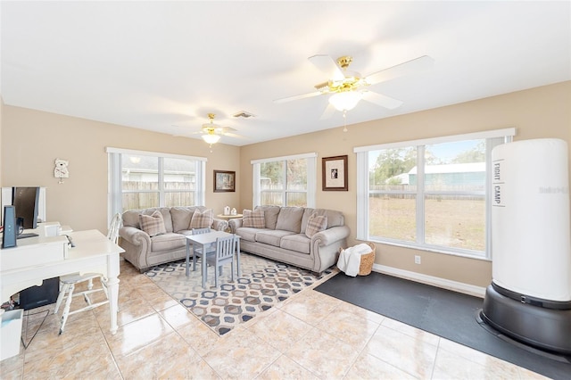 living room featuring ceiling fan, light tile patterned floors, and a wealth of natural light