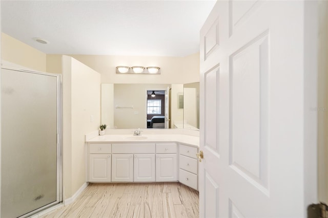 bathroom with wood-type flooring, an enclosed shower, and vanity