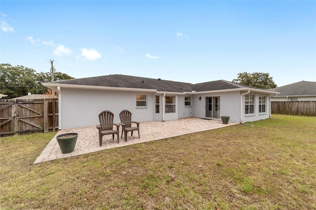 back of house featuring a patio area and a lawn