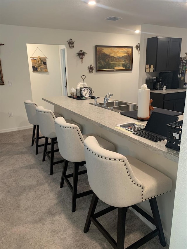 bar featuring sink and light colored carpet