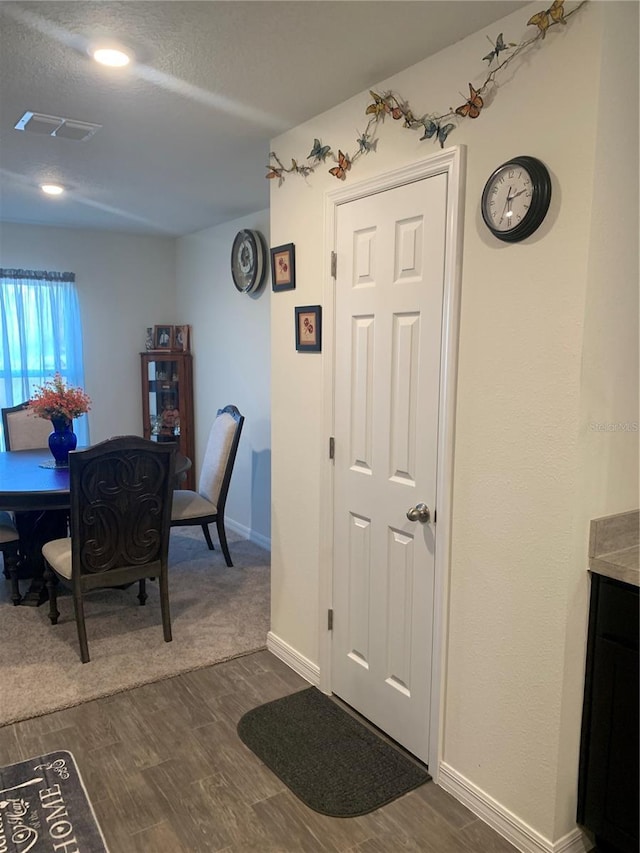 dining space with dark hardwood / wood-style floors and a textured ceiling