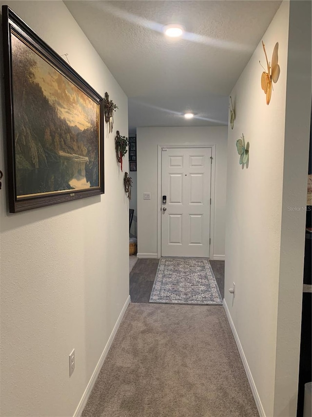 hallway featuring carpet floors and a textured ceiling