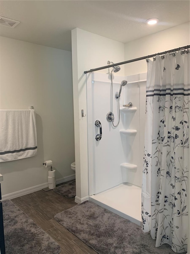 bathroom featuring hardwood / wood-style flooring and curtained shower