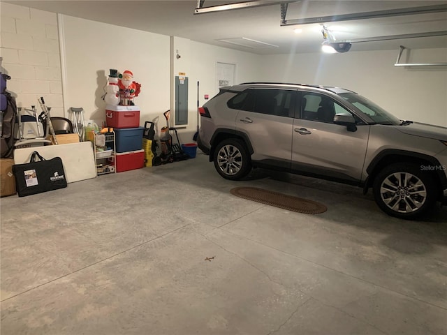 garage with a garage door opener and electric panel