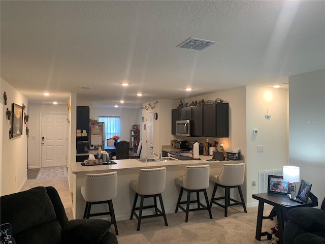 kitchen with stove, sink, kitchen peninsula, and a breakfast bar