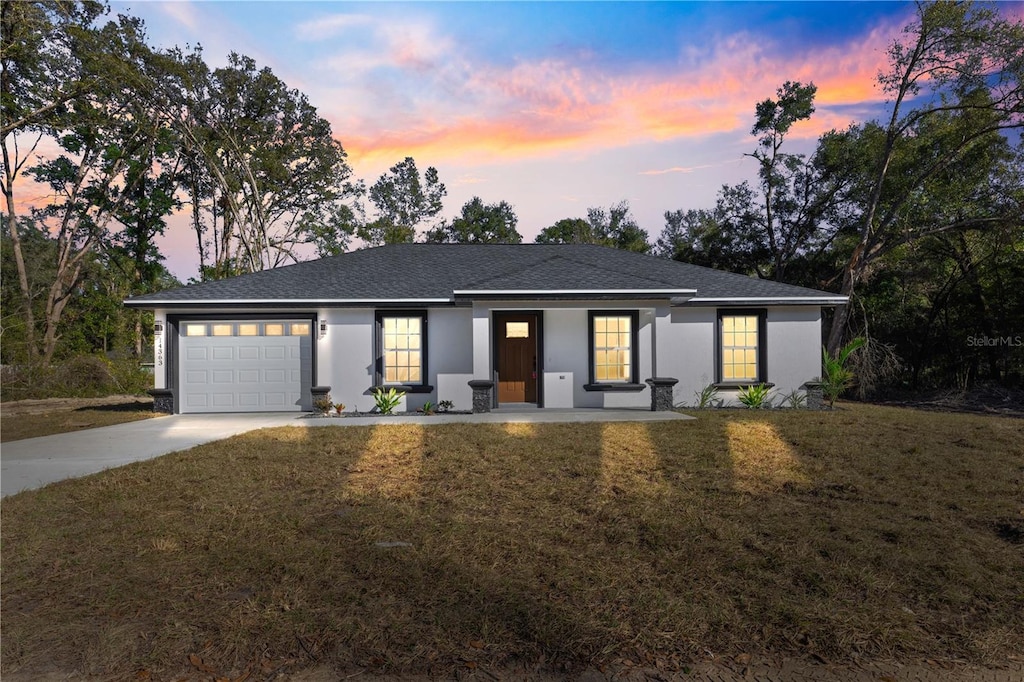 view of front of home featuring a garage, a yard, and covered porch