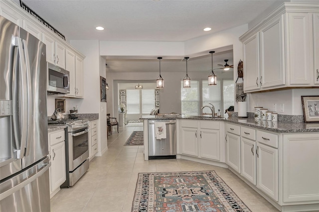 kitchen with ceiling fan, white cabinets, and stainless steel appliances