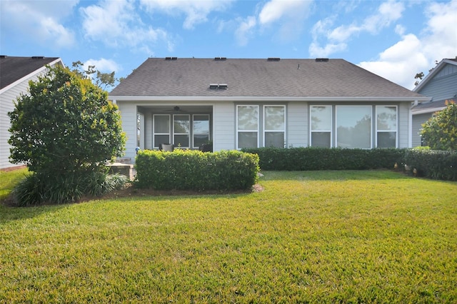 rear view of house featuring a yard