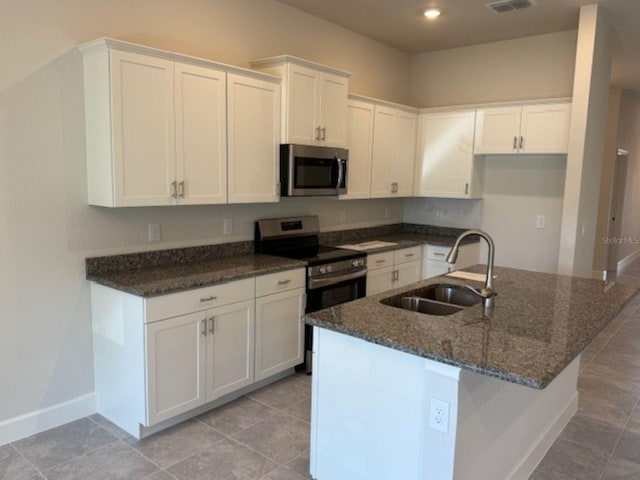 2158 NW 23rd Loop, Ocala, FL 34475 - kitchen with a sink, white cabinetry, appliances with stainless steel finishes, and dark stone counters