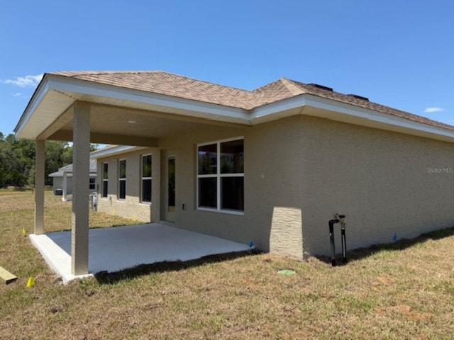 2158 NW 23rd Loop, Ocala, FL 34475 - rear view of house with a patio, stucco siding, and a yard