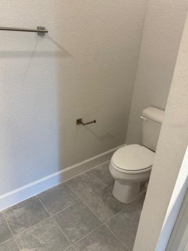2158 NW 23rd Loop, Ocala, FL 34475 - bathroom featuring baseboards, tile patterned floors, and toilet