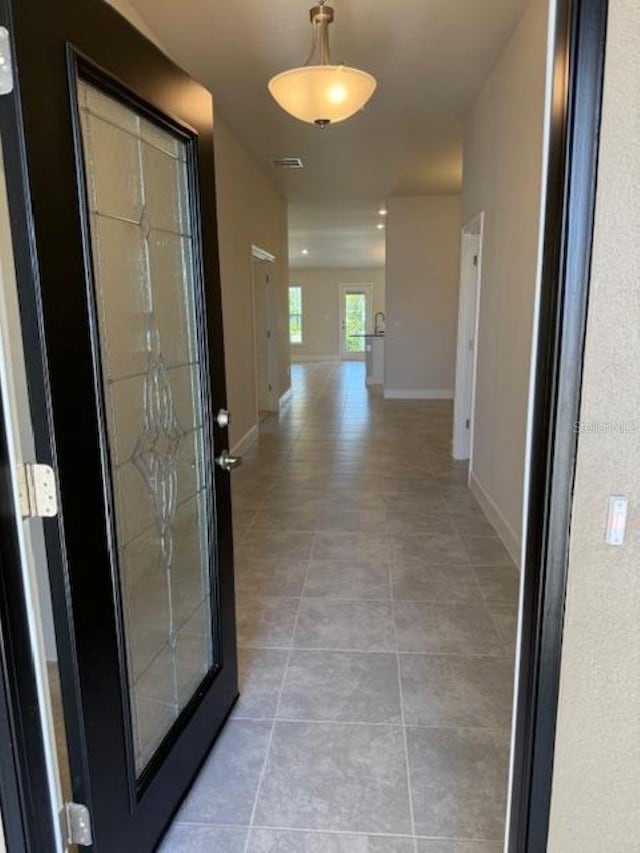 2158 NW 23rd Loop, Ocala, FL 34475 - hallway with baseboards, light tile patterned flooring, and visible vents