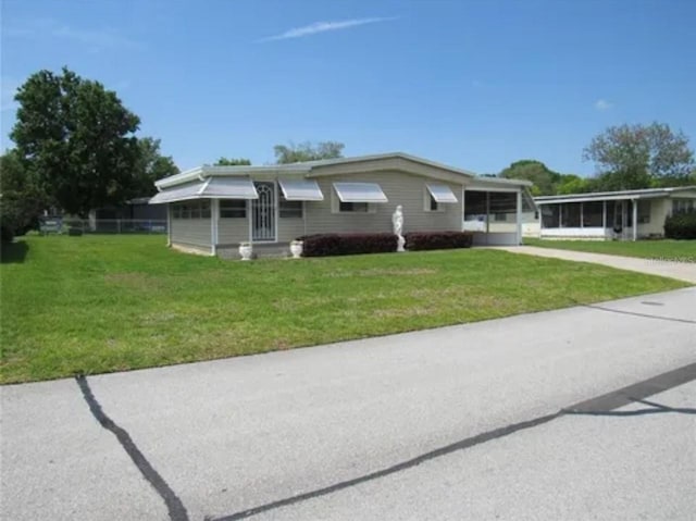 single story home with a front yard and a sunroom