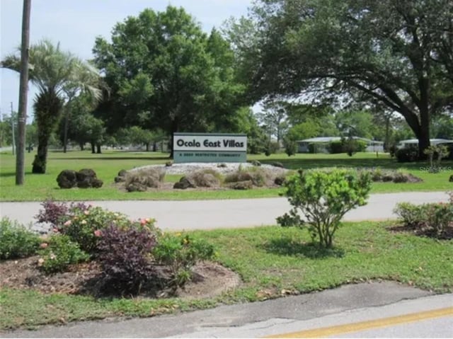 community / neighborhood sign featuring a yard