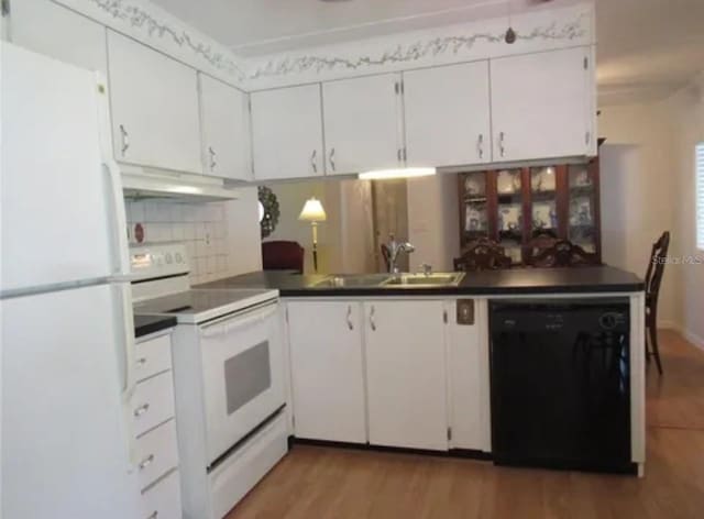 kitchen with white appliances, white cabinetry, sink, backsplash, and hardwood / wood-style flooring