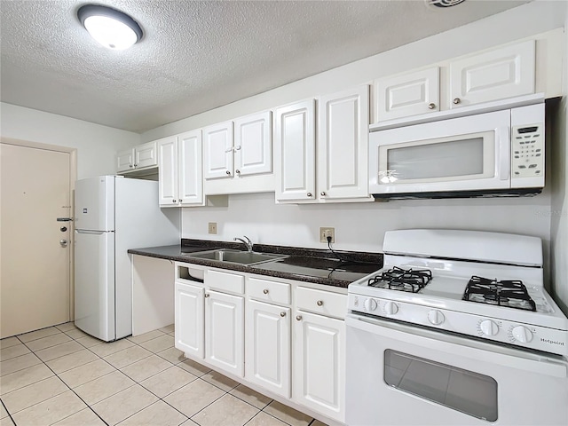 kitchen featuring sink, light tile patterned floors, white appliances, a textured ceiling, and white cabinets