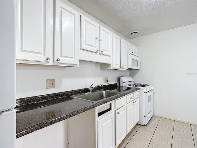 kitchen featuring white cabinetry, sink, white appliances, and light tile patterned floors