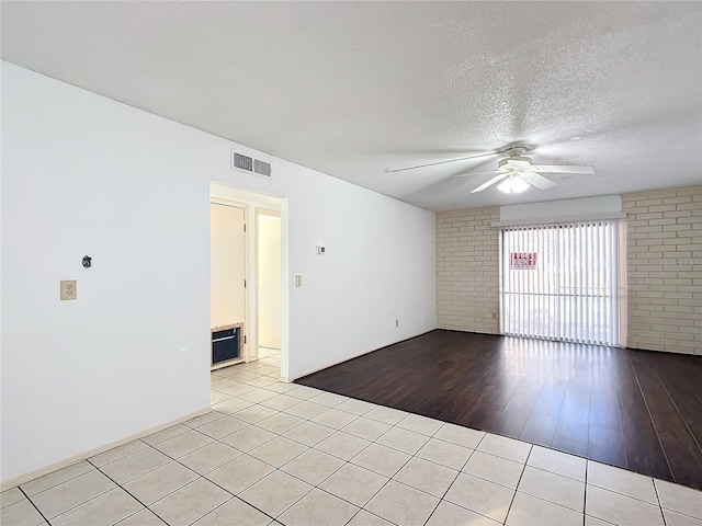 tiled empty room with a textured ceiling and ceiling fan