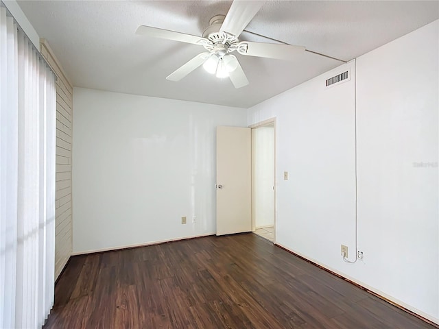 unfurnished room with a textured ceiling, ceiling fan, and dark hardwood / wood-style floors