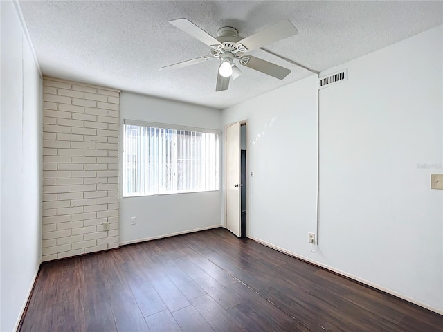 empty room with a textured ceiling, ceiling fan, and dark hardwood / wood-style floors