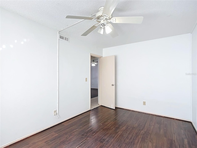 unfurnished room featuring ceiling fan, dark wood-type flooring, and a textured ceiling