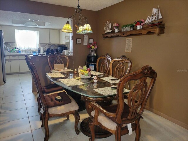 dining area with a textured ceiling, an inviting chandelier, light tile patterned floors, and sink