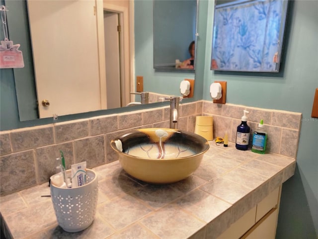 bathroom featuring vanity and tasteful backsplash