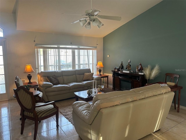 living room with ceiling fan, light tile patterned flooring, lofted ceiling, and a fireplace