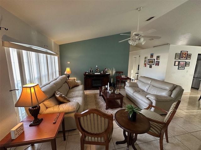 living room featuring ceiling fan, light tile patterned floors, and lofted ceiling