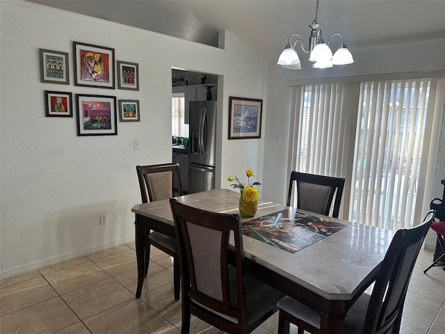 tiled dining room with lofted ceiling and a chandelier