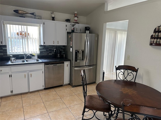 kitchen with stainless steel appliances, decorative backsplash, white cabinetry, and sink