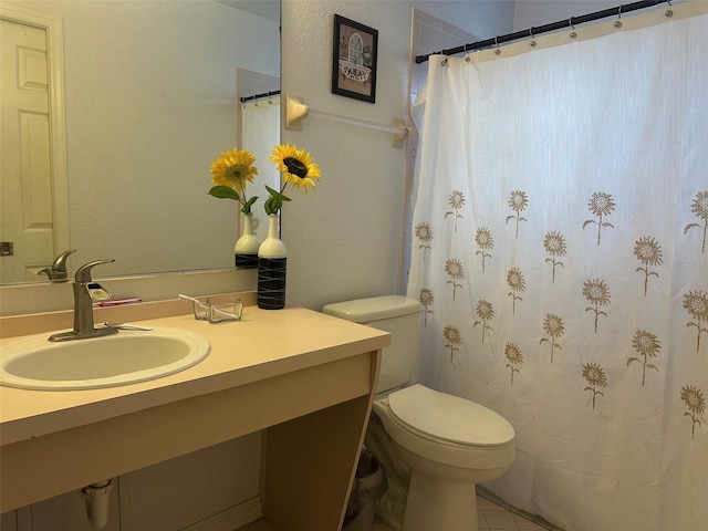 bathroom featuring toilet, vanity, and tile patterned flooring