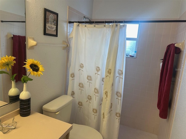 bathroom with toilet and a shower with curtain