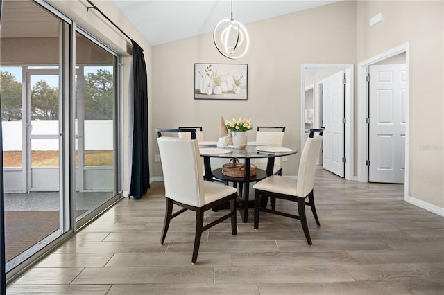 dining area with vaulted ceiling, light wood-type flooring, and baseboards