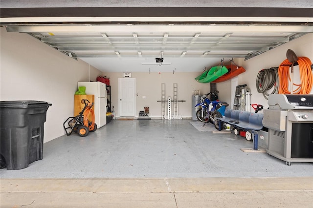 garage with water heater and freestanding refrigerator