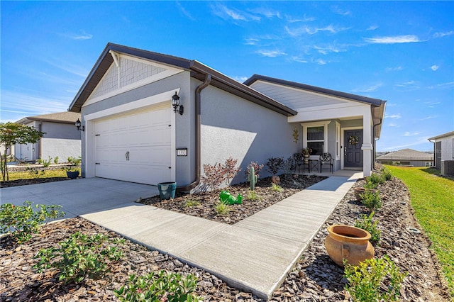 ranch-style home featuring a garage, central AC unit, and a porch