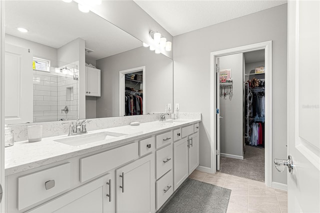 bathroom featuring a textured ceiling, tile patterned flooring, walk in shower, and vanity