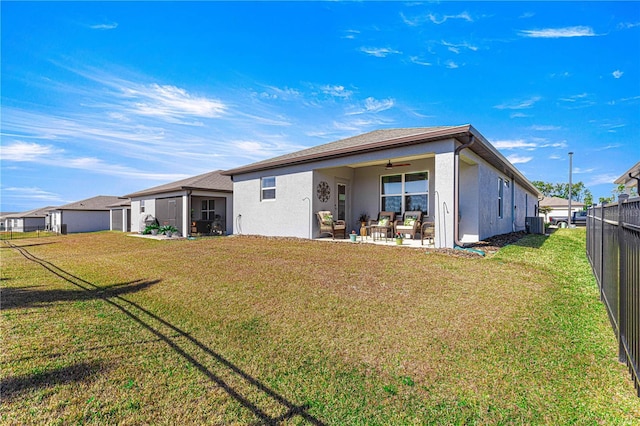 back of house featuring central AC unit, ceiling fan, a patio area, and a yard