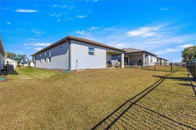 back of property featuring cooling unit and a yard