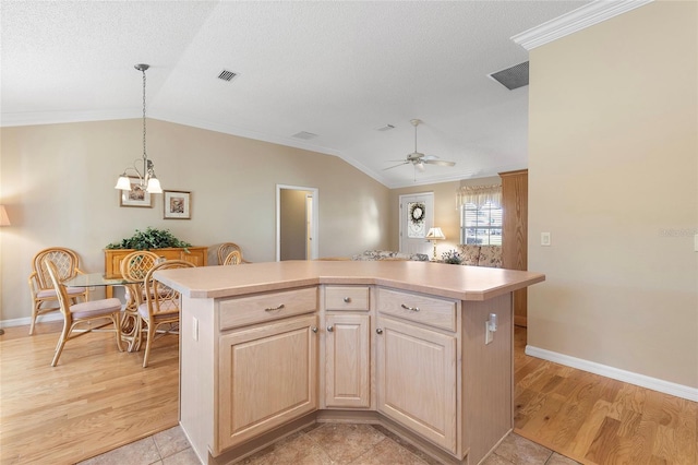 kitchen featuring lofted ceiling, light brown cabinetry, a kitchen island, and light wood-type flooring