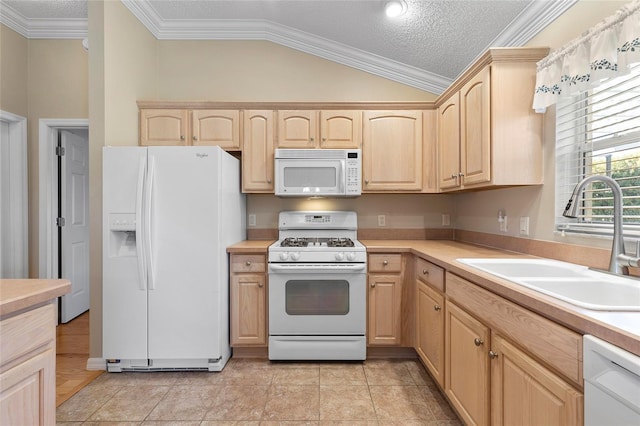 kitchen with sink, white appliances, ornamental molding, light brown cabinetry, and vaulted ceiling