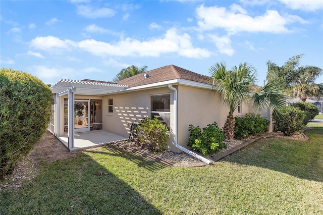 rear view of house with a yard, a pergola, and a patio