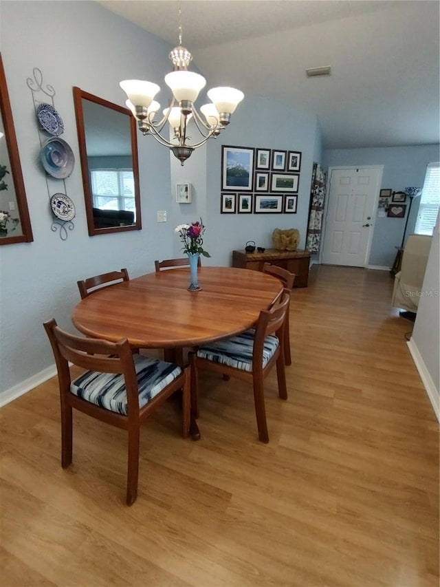 dining area featuring a chandelier and light wood-type flooring