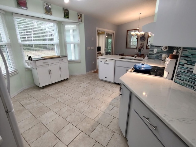 kitchen featuring white cabinetry, white dishwasher, hanging light fixtures, vaulted ceiling, and sink