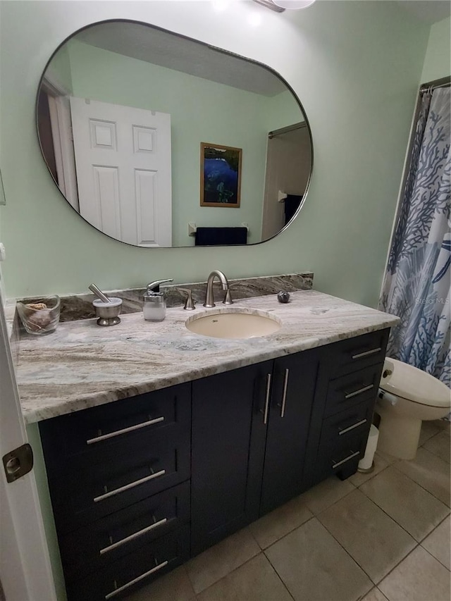 bathroom with toilet, tile patterned flooring, and vanity