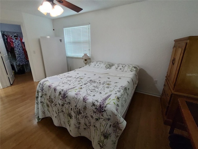 bedroom with ceiling fan and dark hardwood / wood-style flooring