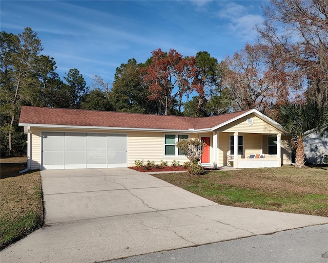 single story home featuring a front yard, a garage, and a porch