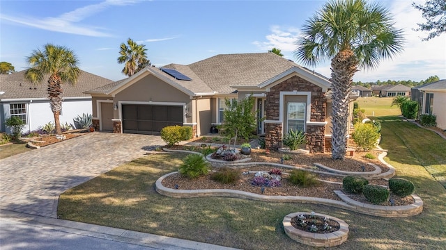 view of front of house featuring a front lawn, solar panels, and a garage