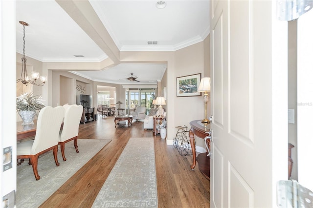 entryway featuring ceiling fan with notable chandelier, hardwood / wood-style floors, and crown molding